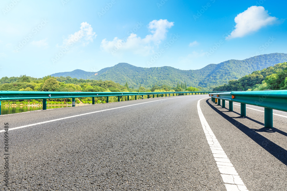 Empty asphalt road and mountains with blue sky on a sunny day