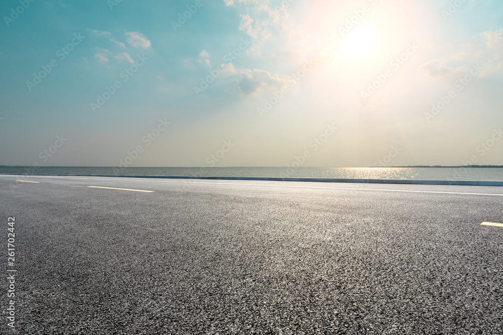 Empty asphalt road and blue sea with sky background