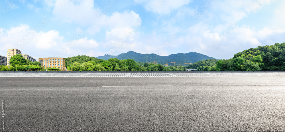 Empty asphalt road ground and mountains with blue sky on a sunny day