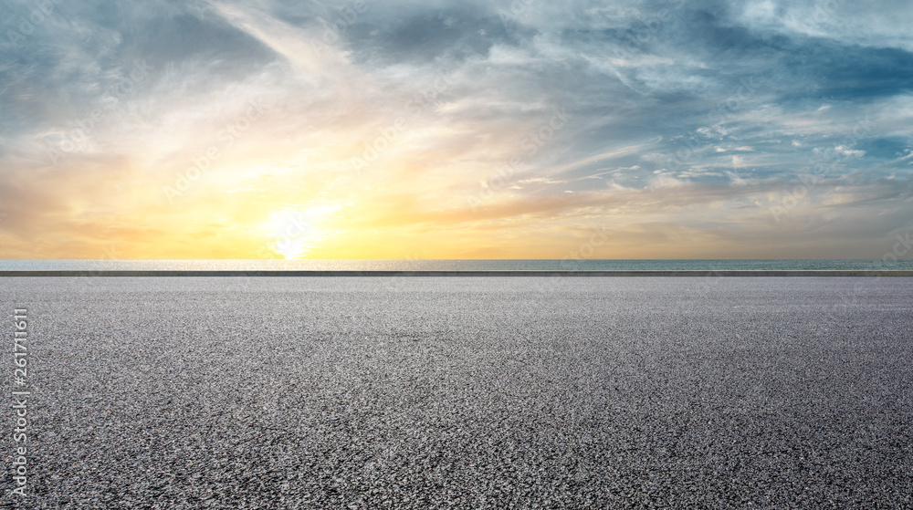 Empty asphalt road and sea with beautiful clouds at sunset