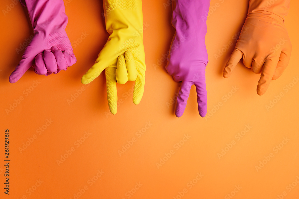 Hands in rubber gloves showing different gestures on color background