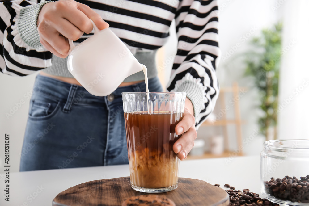 女人在餐桌上准备美味的frappe咖啡