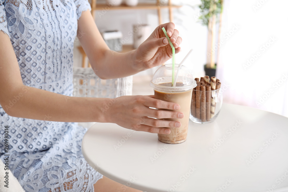 女人在餐桌上喝美味的frappe咖啡