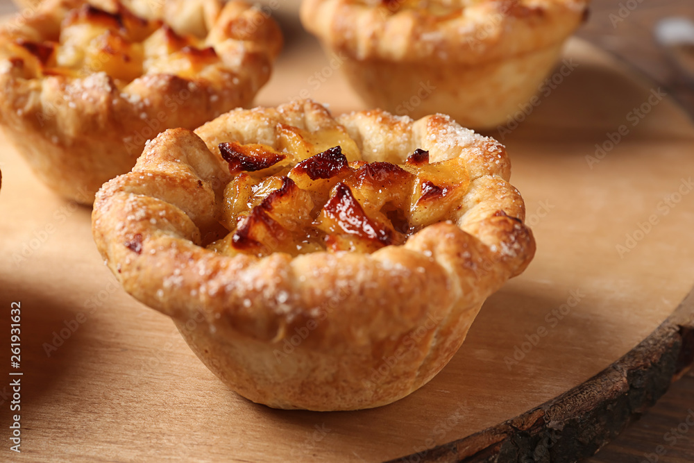 Tasty apple pies on wooden board, closeup