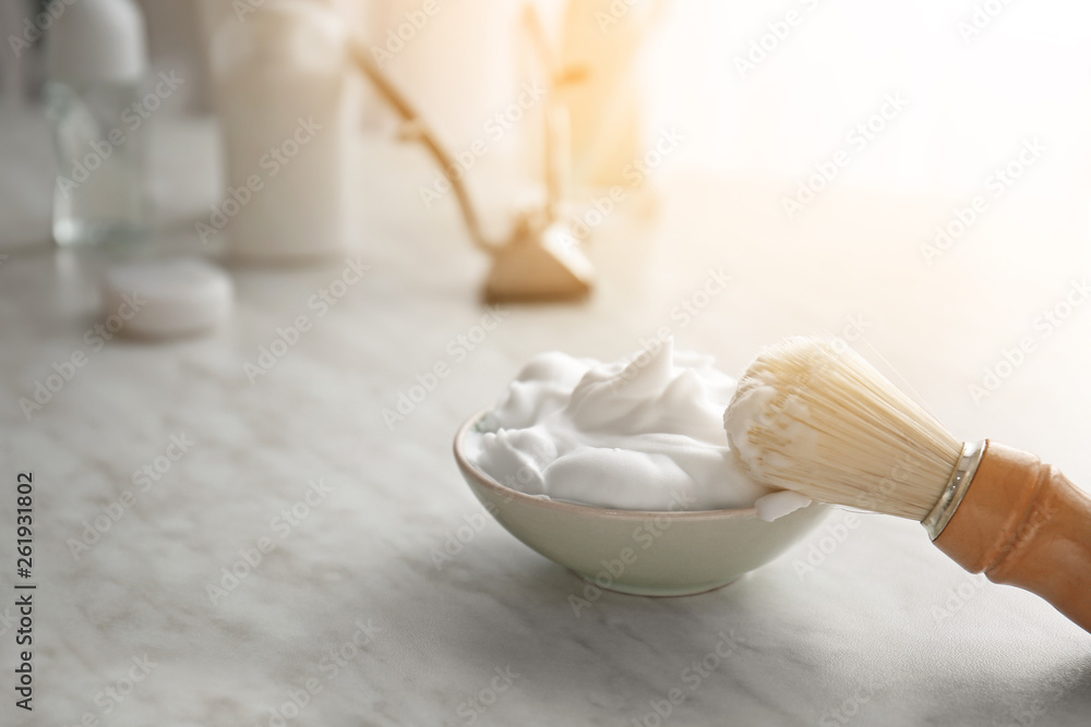 Bowl with shaving foam and brush on table