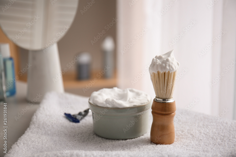 Bowl with shaving foam and brush on table