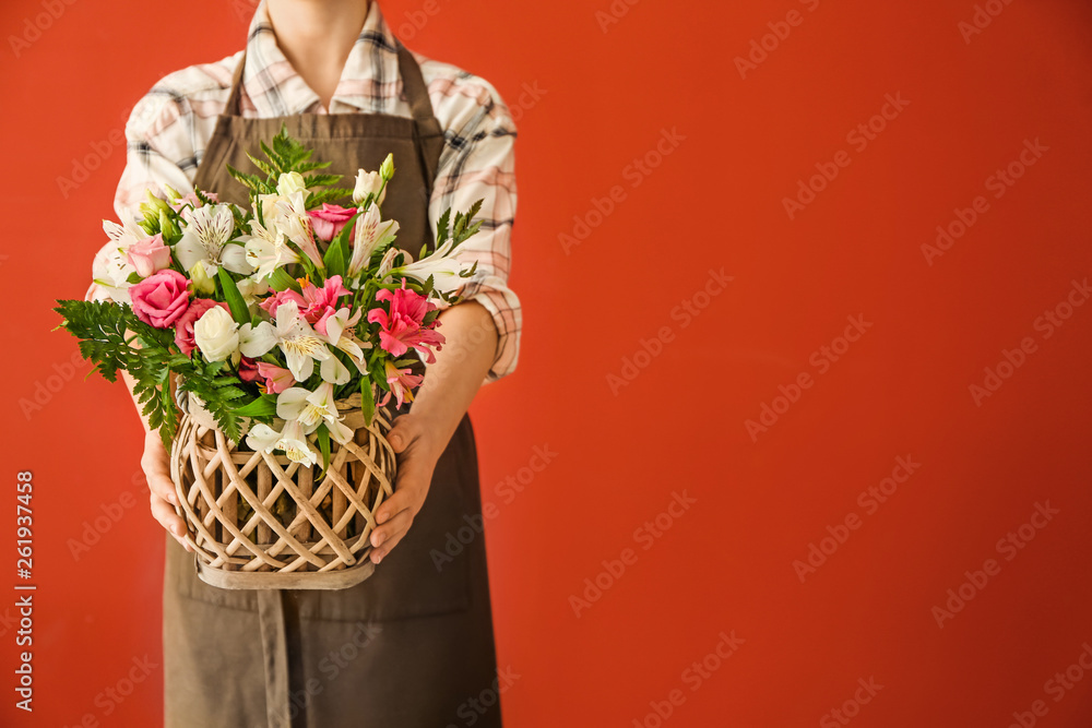 花艺师手持彩色背景的美丽花束