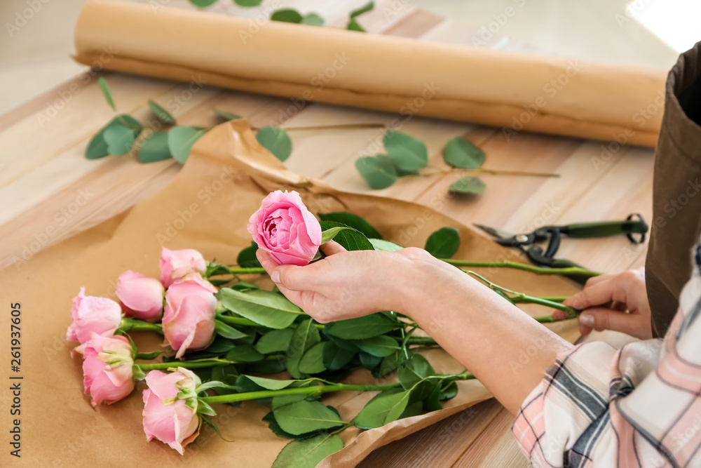 Florist making beautiful bouquet at table