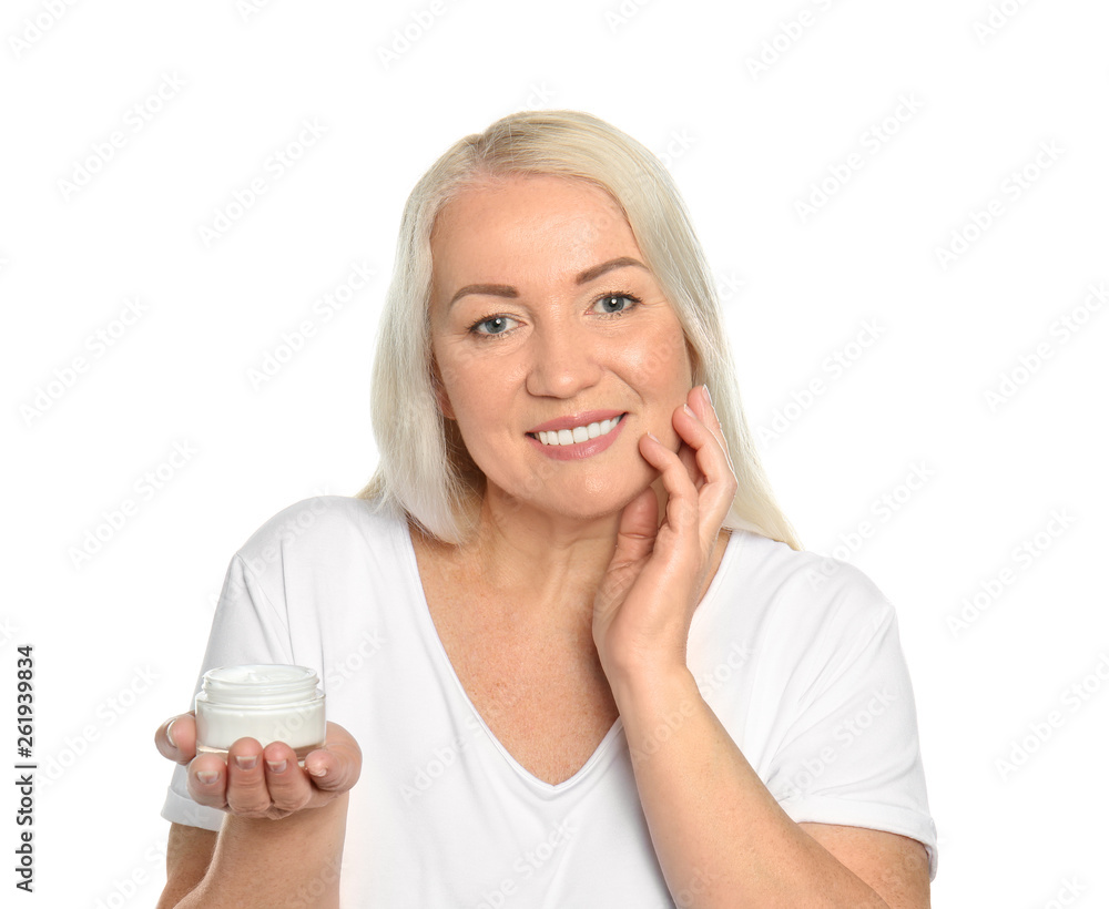 Mature woman applying facial cream on white background