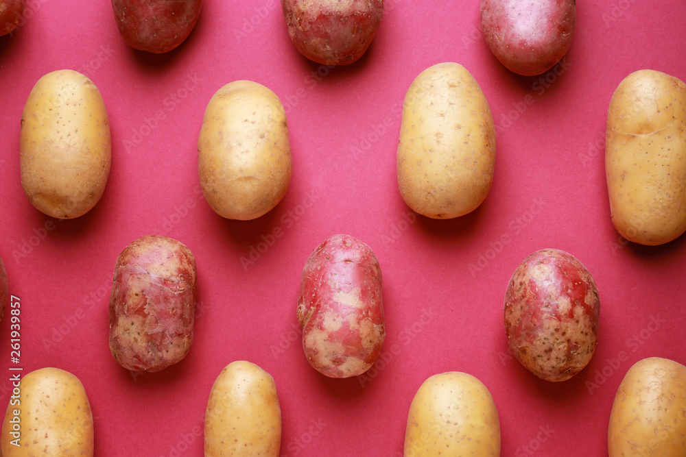 Raw potatoes on color background