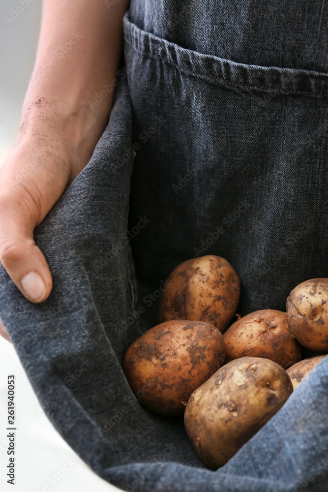 Woman with raw potatoes, closeup