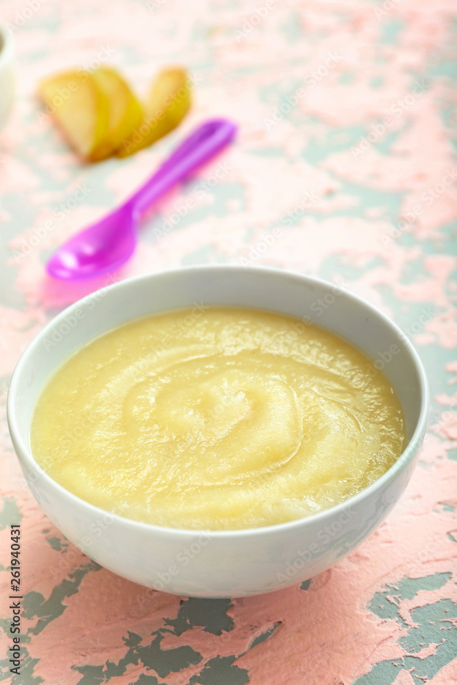 Bowl with healthy baby food on table