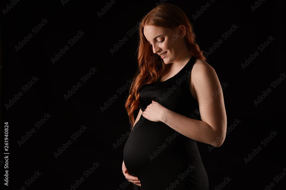 Beautiful pregnant woman on dark background