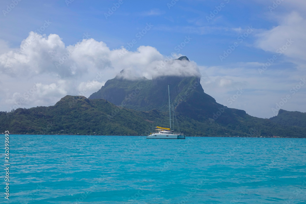 DRONE: Big brand new sailboat exploring the ocean surrounding the remote island.