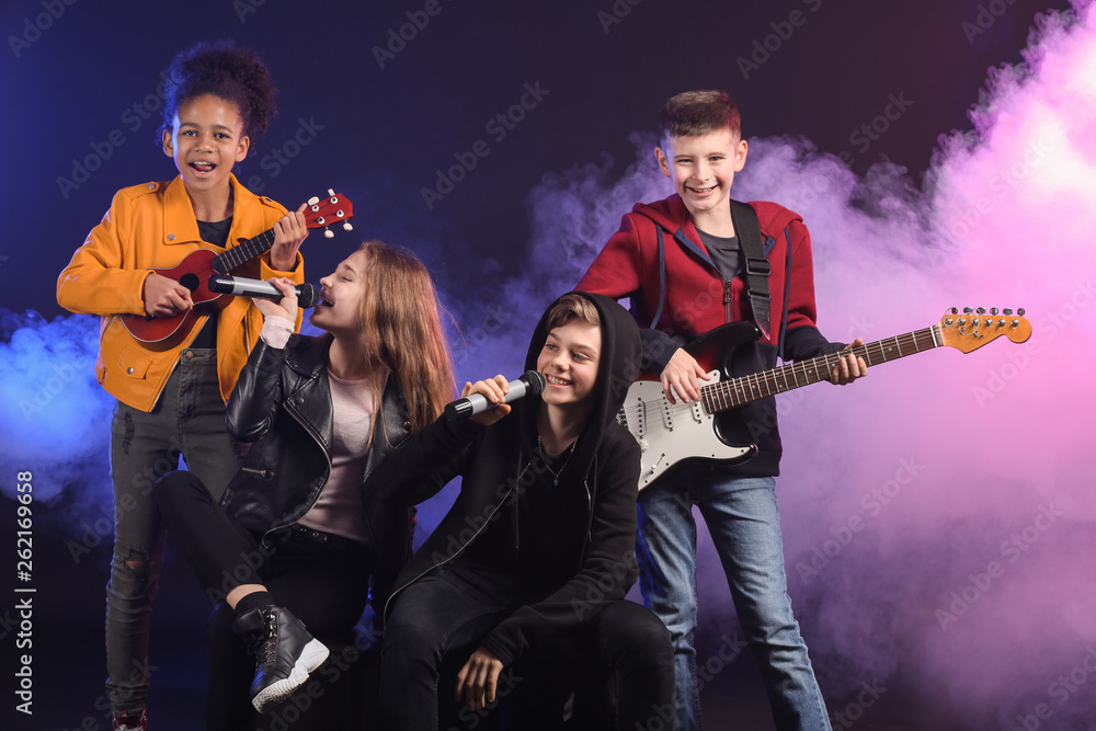 Band of teenage musicians on dark background