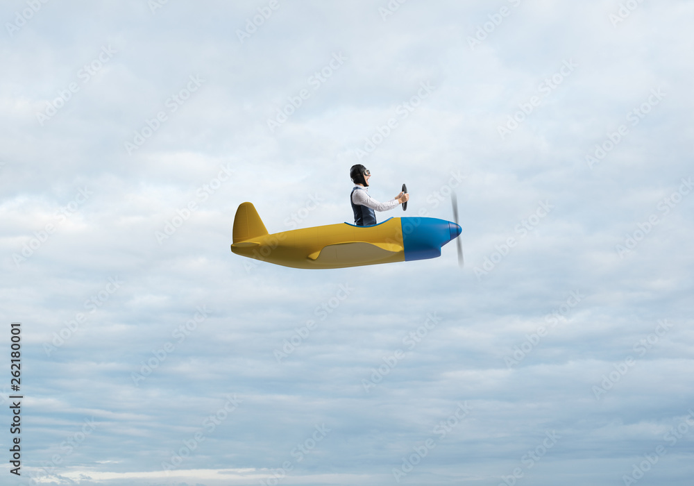 Man in aviator hat driving propeller plane