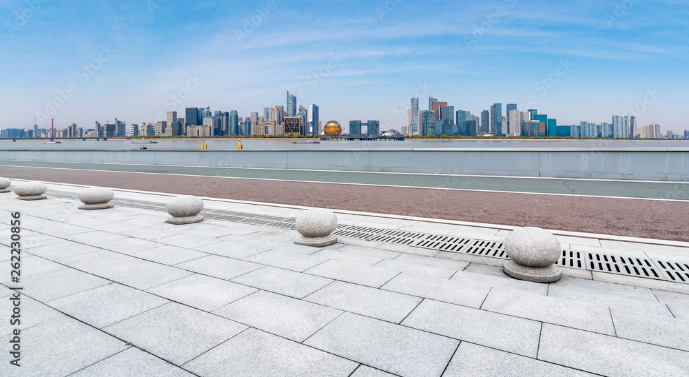 Empty square tiles and skyline of urban buildings..