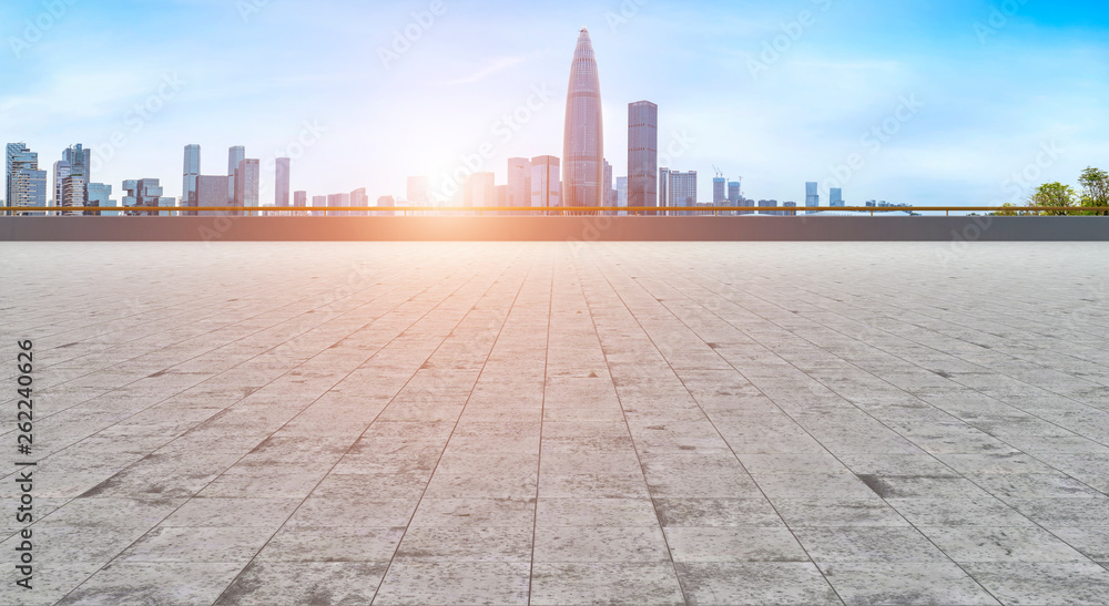 Empty square tiles and skyline of urban buildings