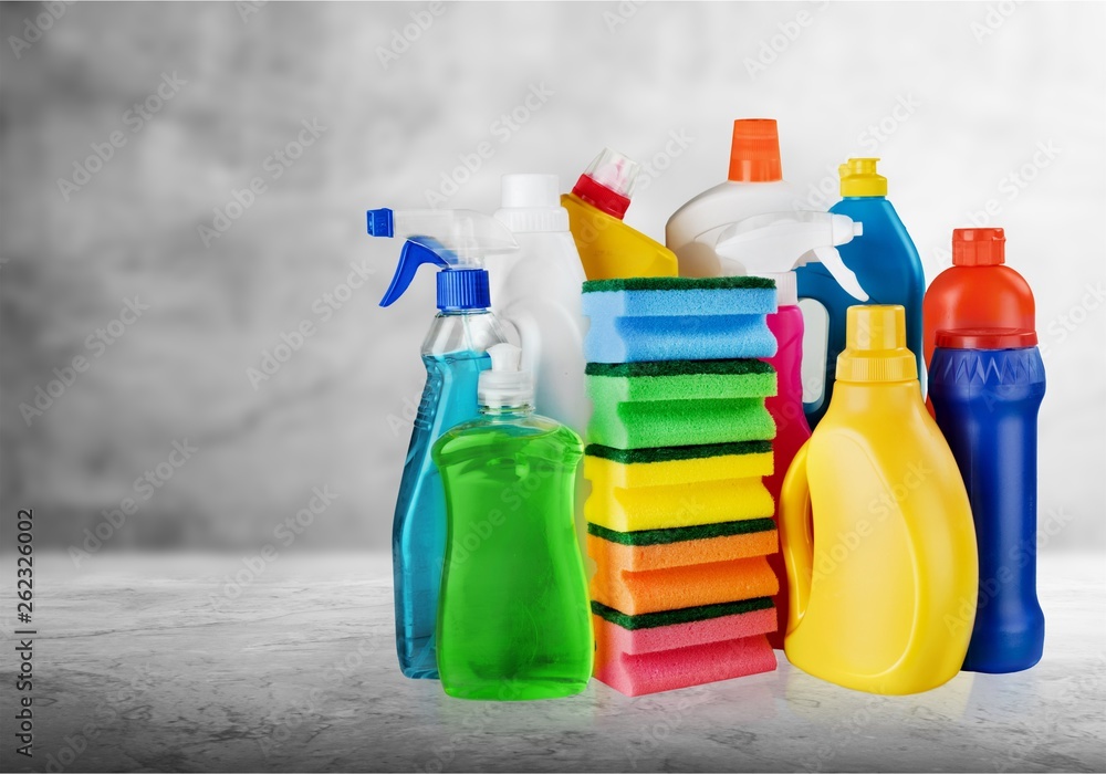 Cleaning products in bucket on background