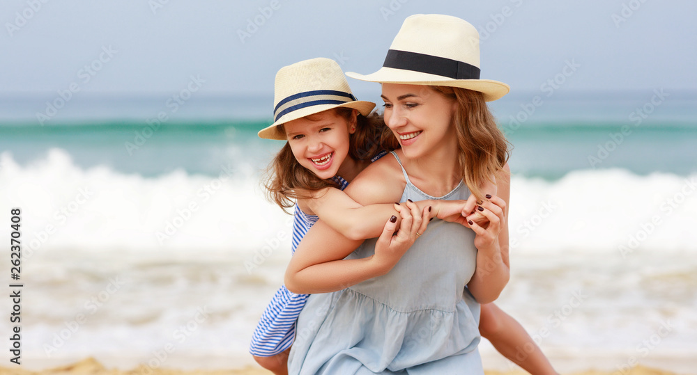 happy family at beach. mother and child daughter hug at sea