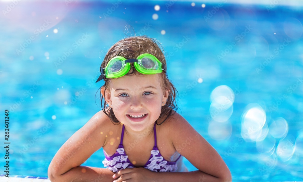 Beautiful little girl swimming at the pool