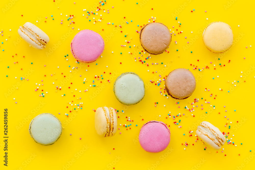 Macarons design on yellow background top view pattern