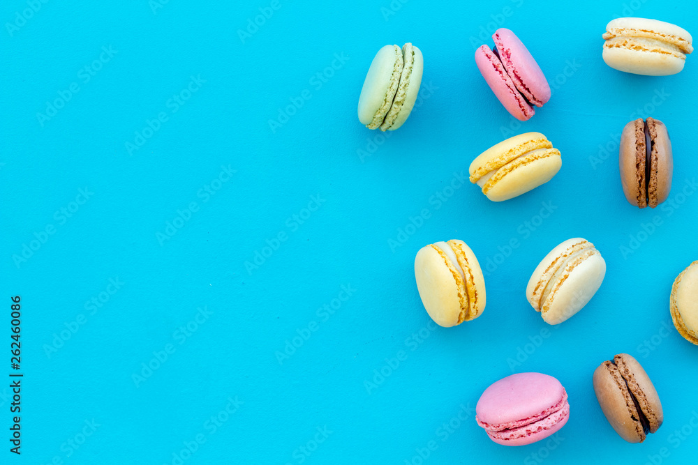 Brignt macarons for sweet break on blue background top view mock up