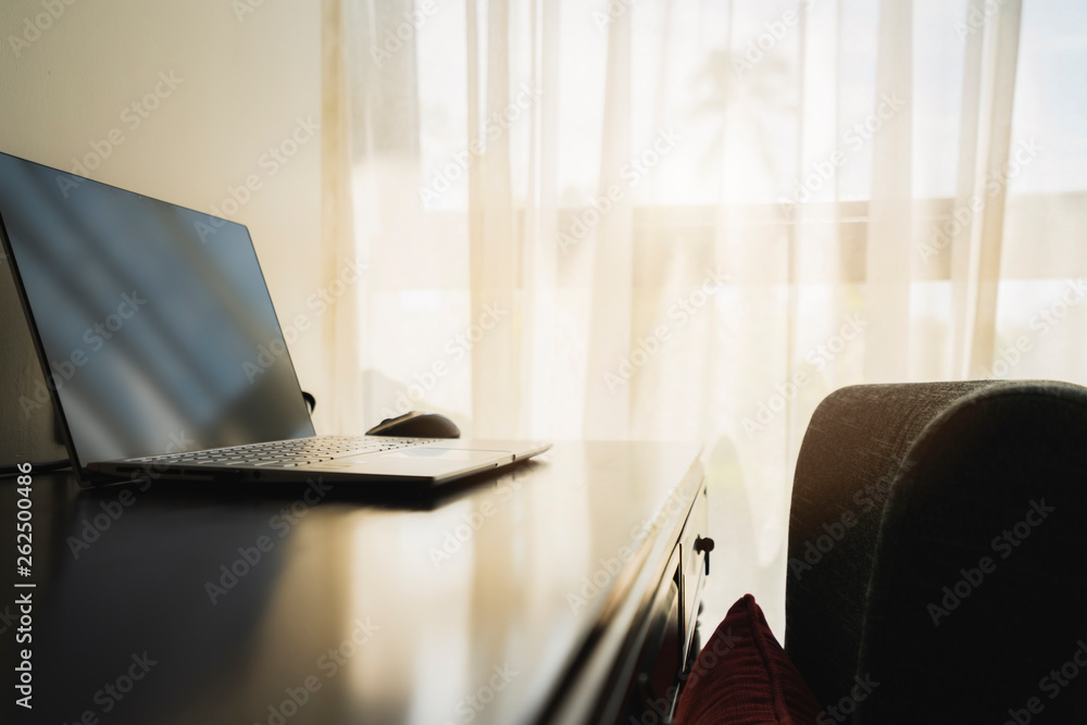 working table corner with laptop and working chair with white curtain background