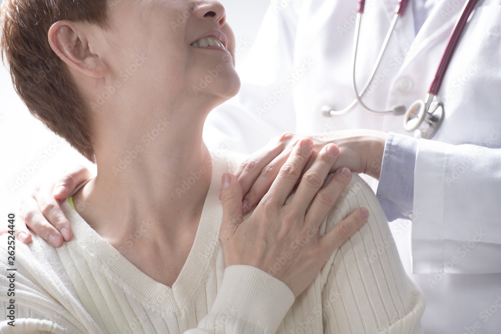 Medical doctor reassuring senior patient and putting a hand on patient’s shoulder