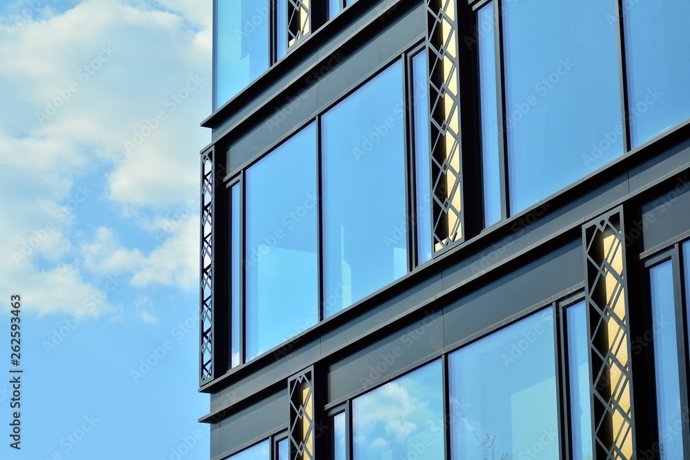 Modern office building wall made of steel and glass with blue sky