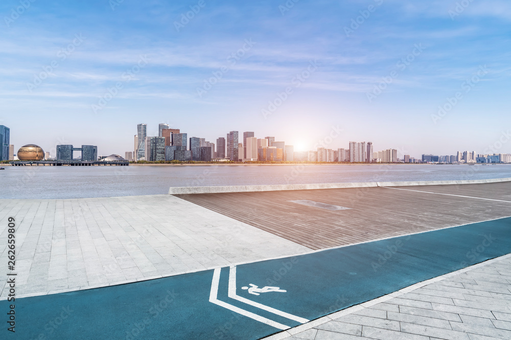 Empty square tiles and skyline of urban buildings..