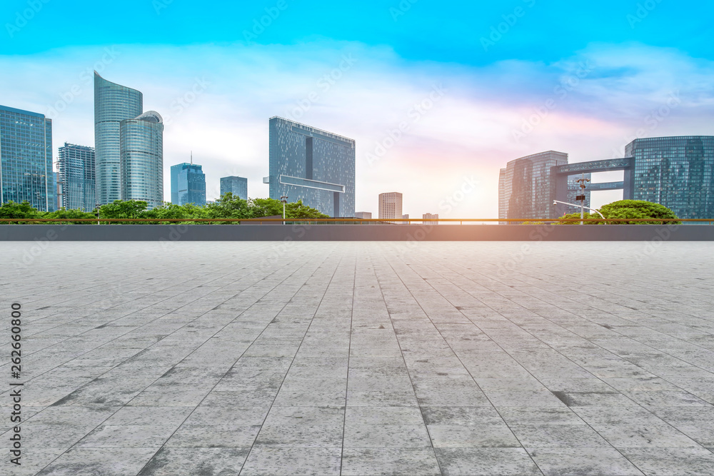 Empty square tiles and skyline of urban buildings..