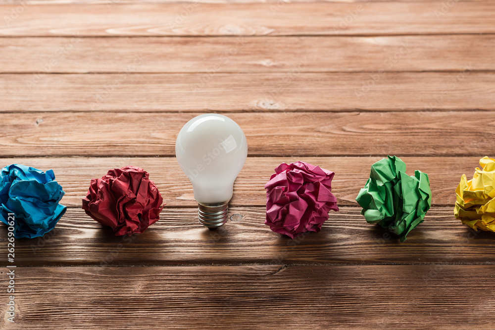 Ideological concept with wastepaper light bulb on wooden table