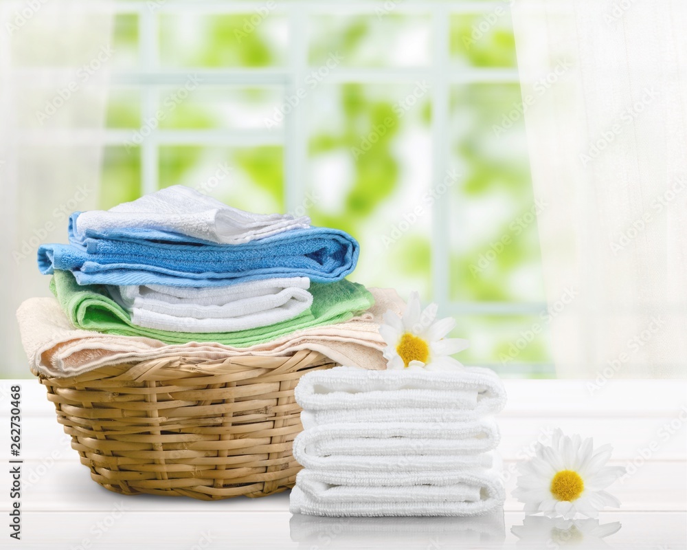 Laundry Basket with colorful towels on background