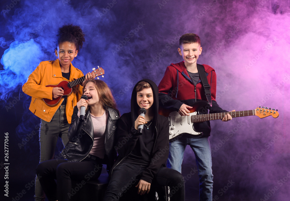 Band of teenage musicians on dark background