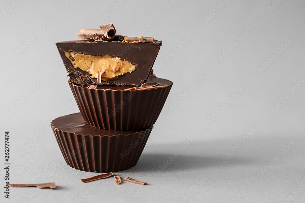 Tasty chocolate peanut butter cups on grey background