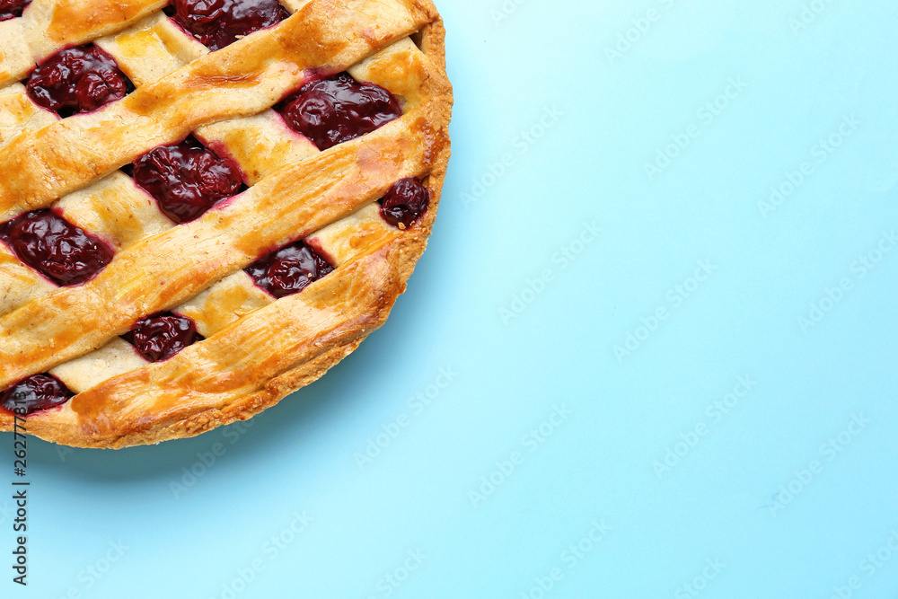 Tasty cherry pie on color background