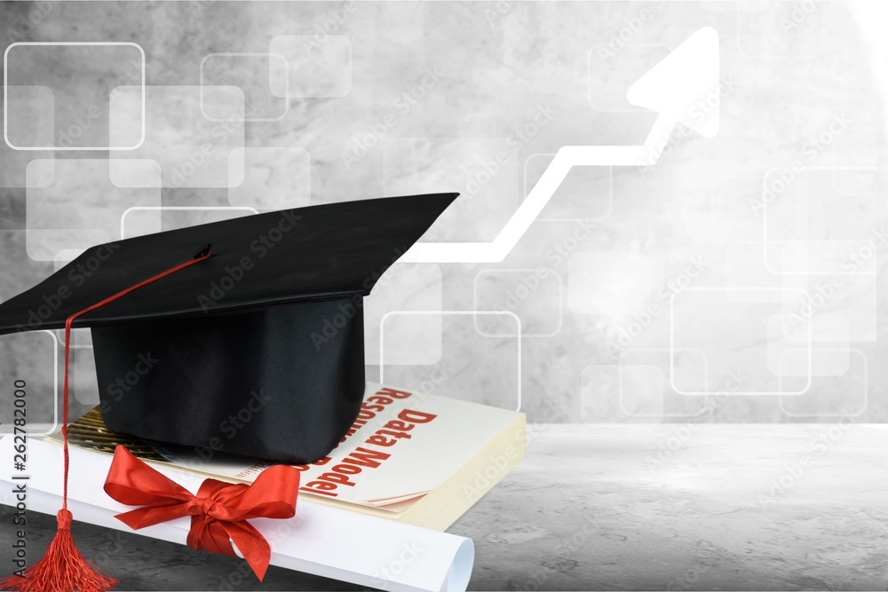 Graduation hat with tassel, diploma with red ribbon