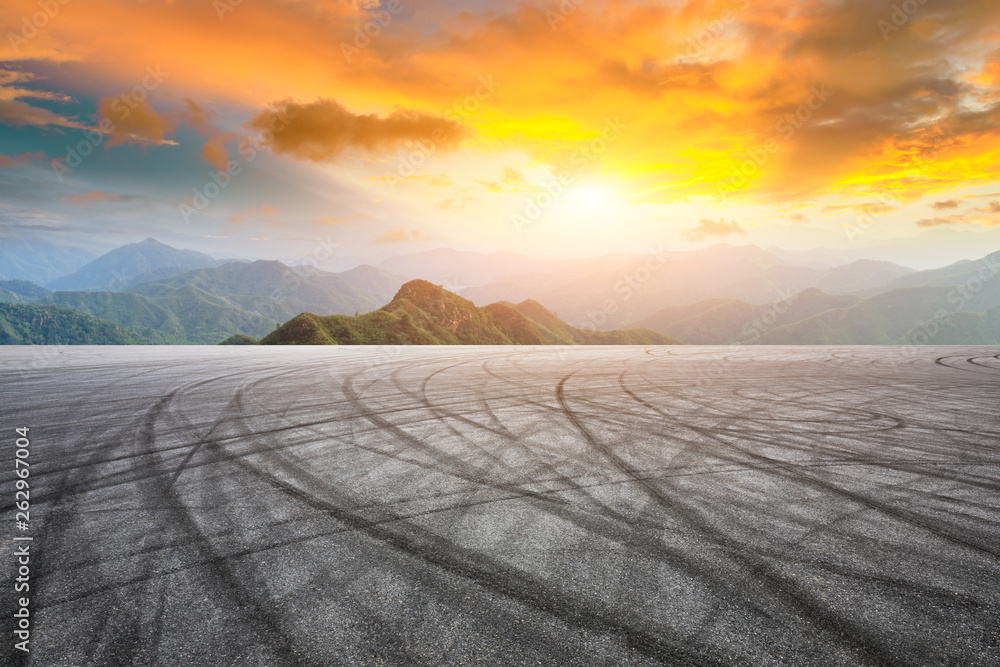 Asphalt race track ground and mountain with sunset clouds