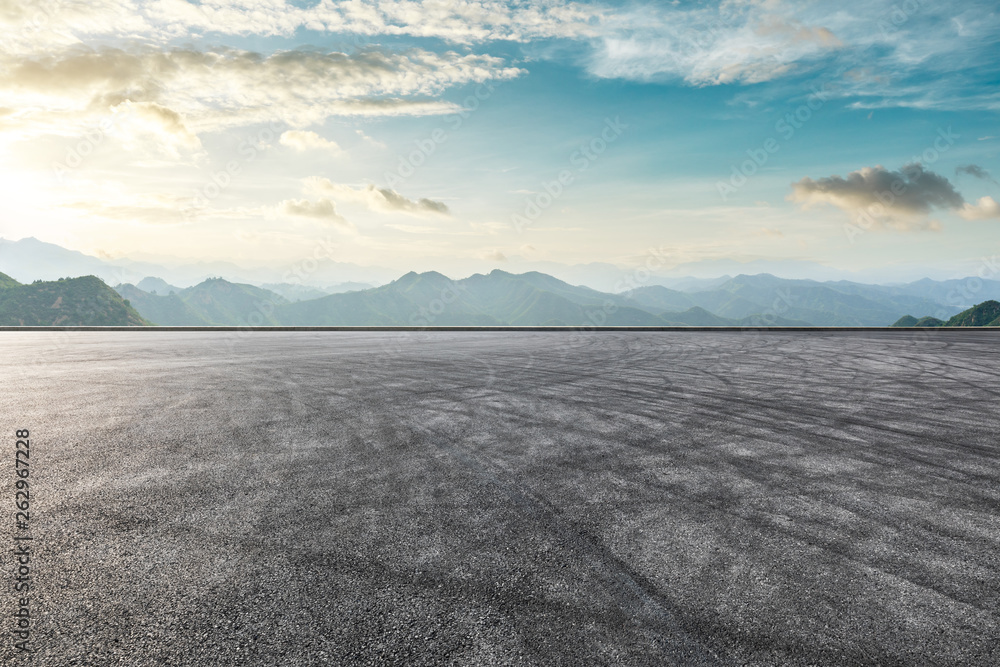 Asphalt race track ground and mountain with sunset clouds