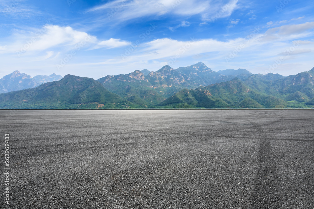 Asphalt race track ground and mountain with clouds background