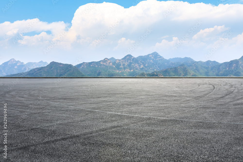 Asphalt race track ground and mountain with clouds background