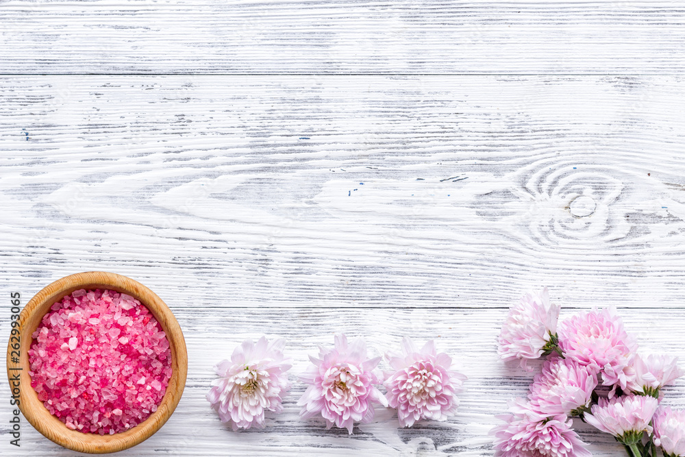 pink spa salt for aroma therapy with flower fragrance on white wooden background top view copyspace