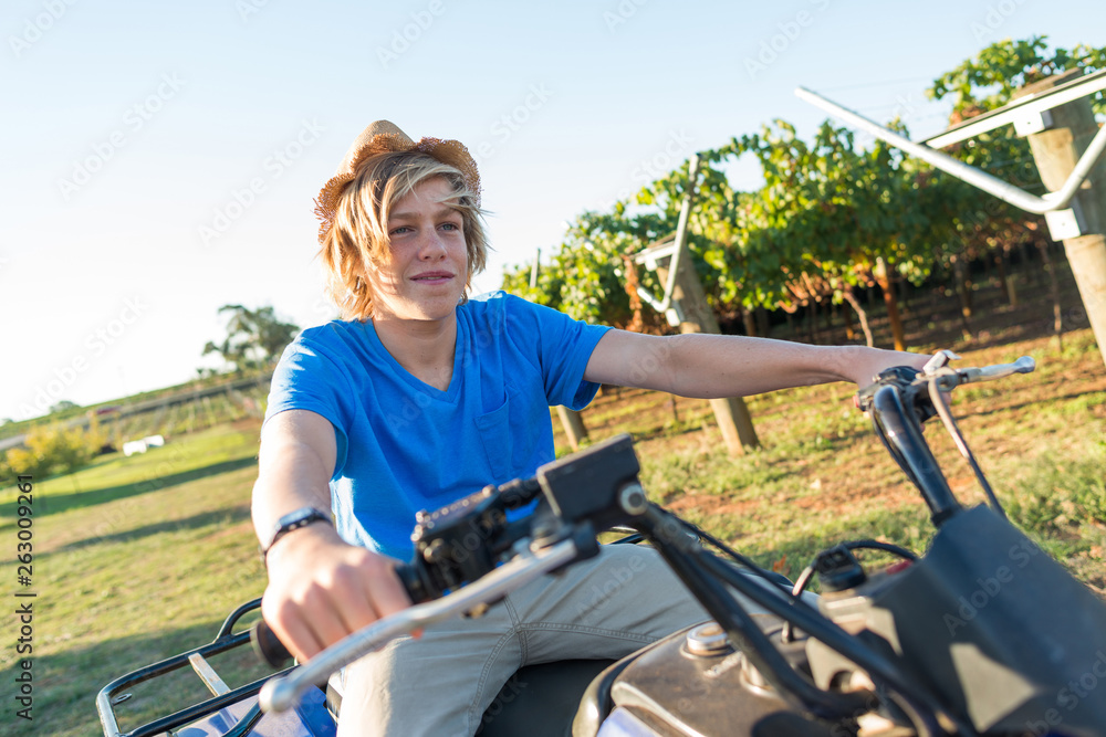 Young farmer riding quad bike