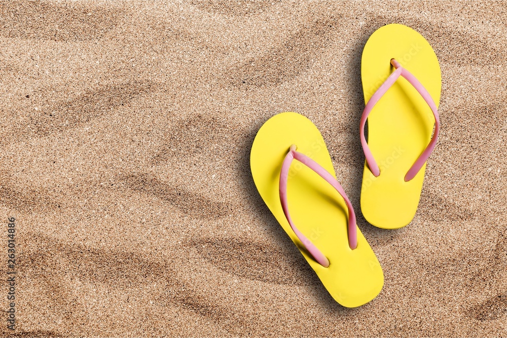 Yellow rubber sandals flip flops on wooden background