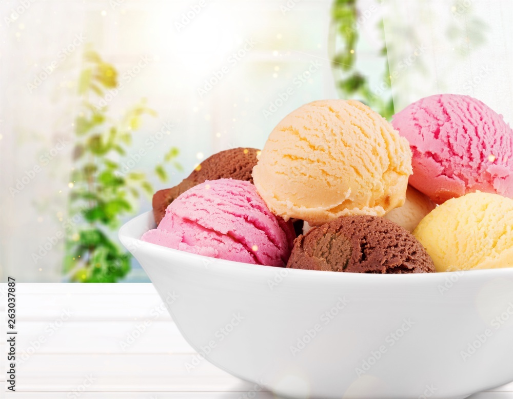 Ice cream scoops in bowl on white background