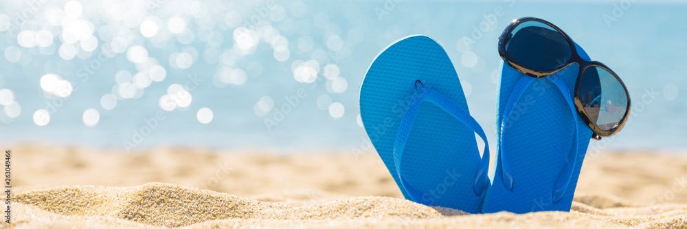 flip flops with sun glasses on sunny tropical Caribbean beach, turquoise waters on caribbean island,