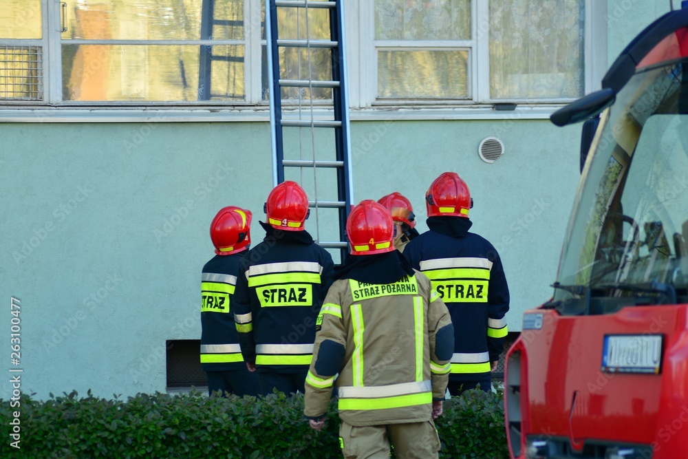 Many firemen during rescue operations with a big ladder