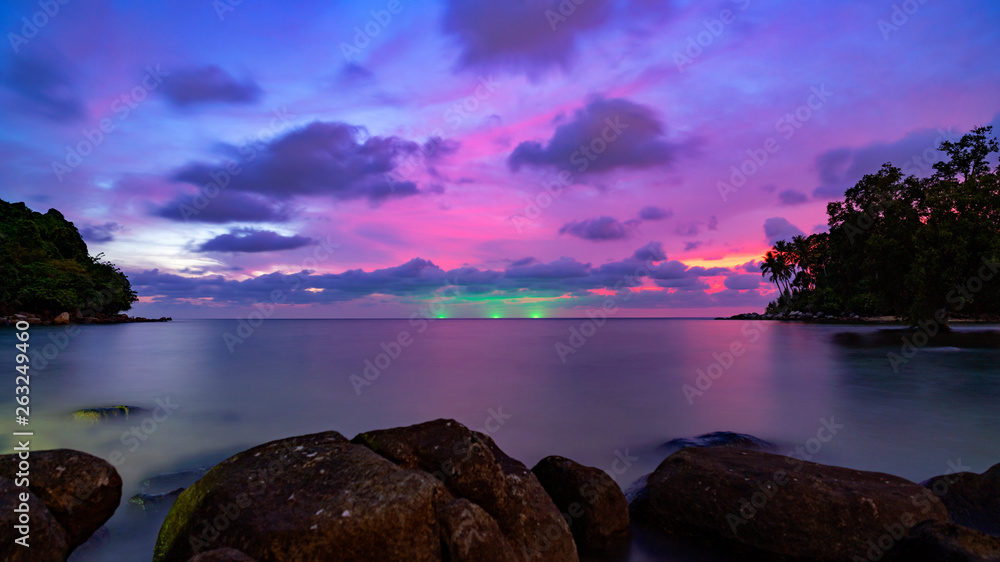 Long exposure image of Dramatic sky seascape with rock in sunset scenery background