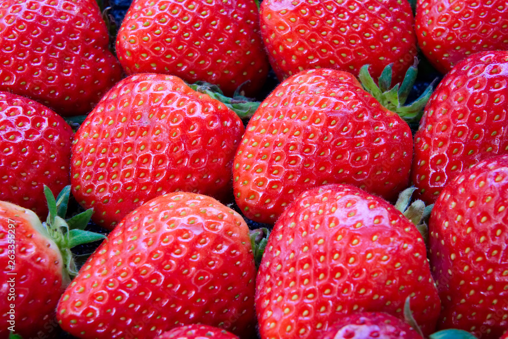 Close up view of dozen of fresh red strawberries. Delicious and juicy tasty fruit. Seen from the sid